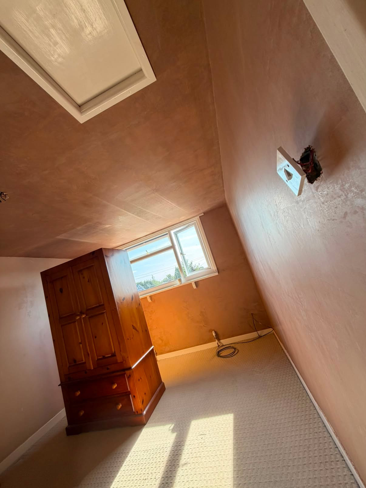 Loft bedroom skimmed right into the sloped ceiling and around the hatch